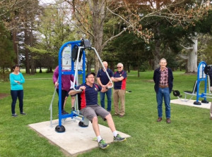 A man tries out new outdoor fitness equipment