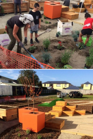 People plant a new garden beside orange planters