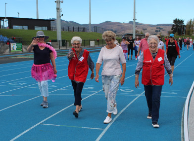 four women walking at sports ground